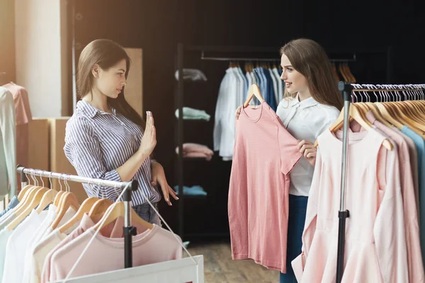 Dos chicas eligiendo ropa en la tienda — Foto de Stock