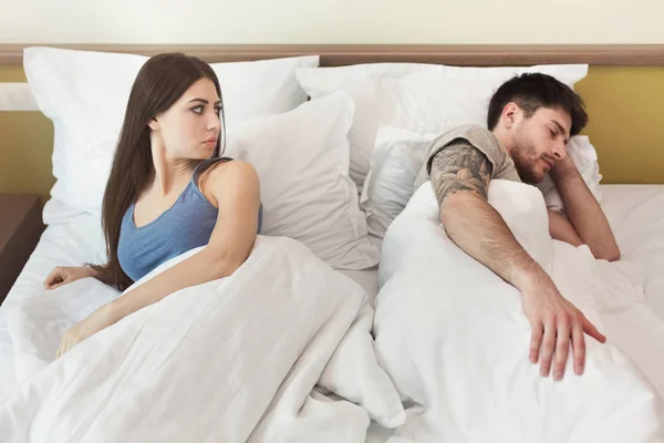Frau sieht Mann nach Streit schlafend an — Stockfoto