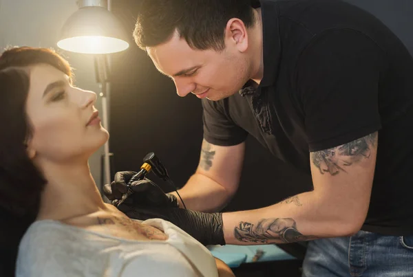 Tattoo artist working with needle on clients body — Stock Photo, Image