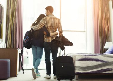 Seven genç çift otel odasında pencereden bakıyor