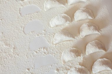 Tablo üzerinde ham el yapımı vareniki un serpilir