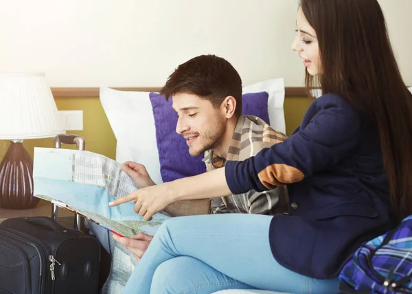 Jong koppel planning reis met kaart in hotelkamer — Stockfoto