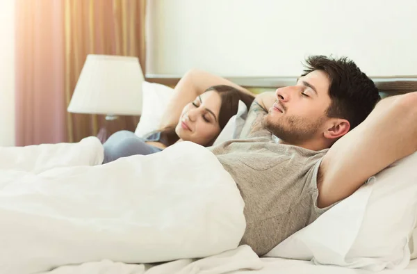 Pareja joven durmiendo en la cama en el dormitorio —  Fotos de Stock