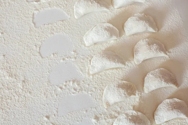 Tablo üzerinde ham el yapımı vareniki un serpilir