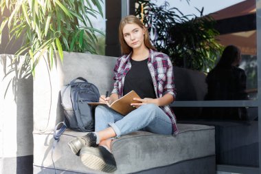 Genç öğrenci kız notları not defterinde yapma