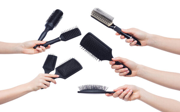 Female hands holding various brushes isolated on white