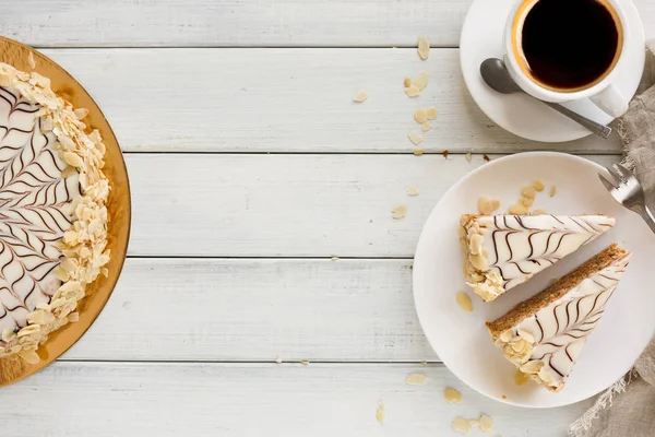 Kahve Kupası en iyi manzaralı beyaz tabakta Esterhazy pasta dilimlenmiş. Şarküteri şekerli tatlı badem beze hamur ve buttercream, geleneksel Macarca, Avusturya mutfağı ile.