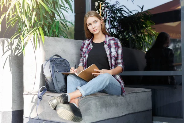 Genç öğrenci kız notları not defterinde yapma