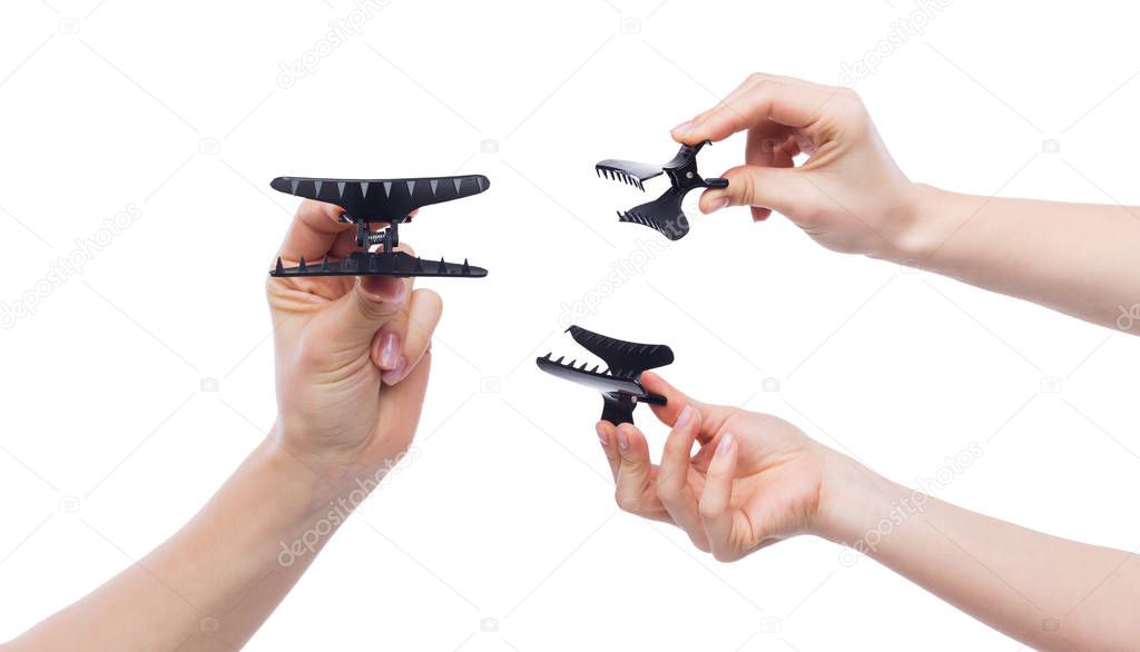 Females hands holding hairclips opened isolated on white background