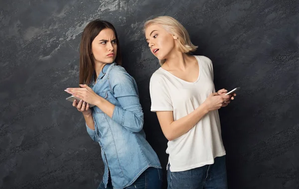 Girls overseeing into each other phones — Stock Photo, Image