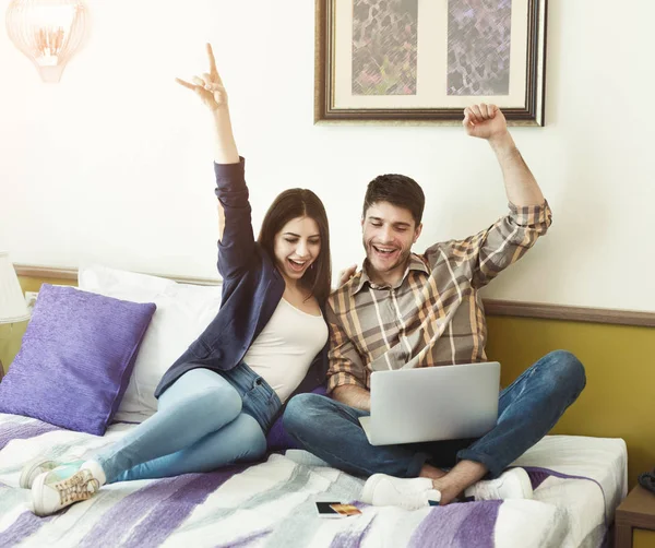 Casal feliz usando laptop no quarto de hotel — Fotografia de Stock