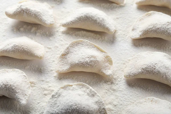 Tablo üzerinde ham el yapımı vareniki un serpilir