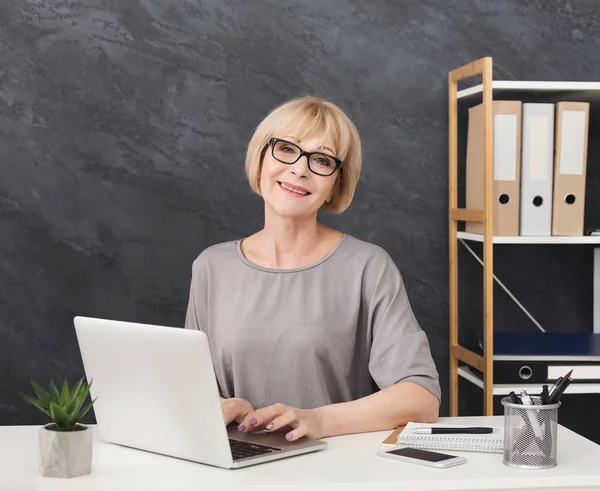 Professional female administrative manager working on laptop in office