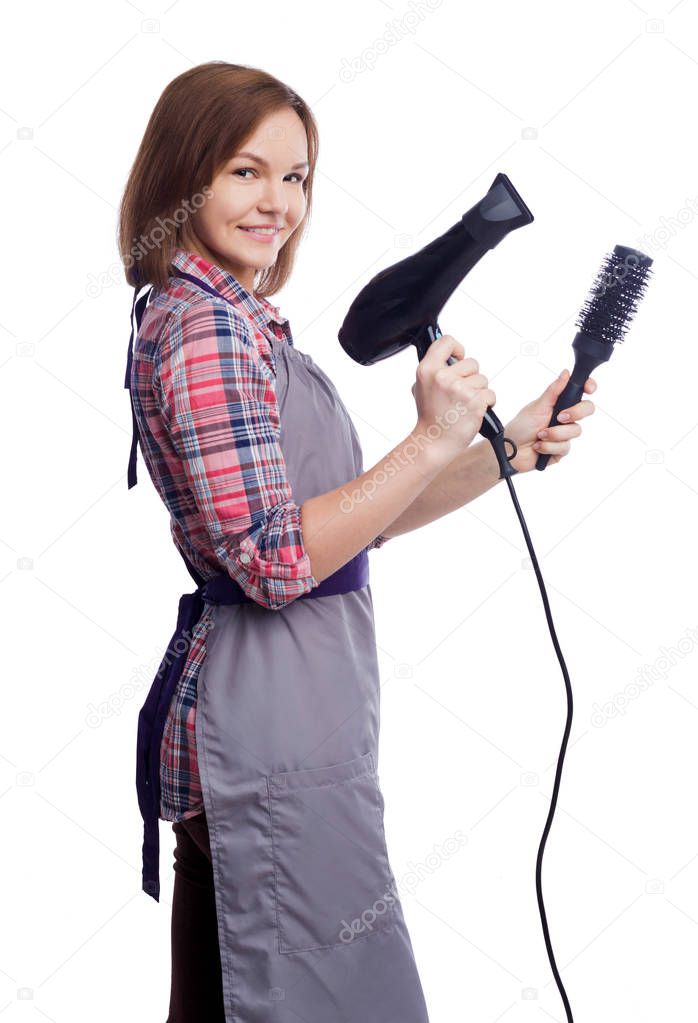 Happy hairdresser holding hairdryer and brush on white backgropund