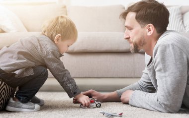 Baba ve küçük çocuk oyuncakları ile oynarken