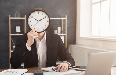Adam yüzünü kaplayan büyük saat ile