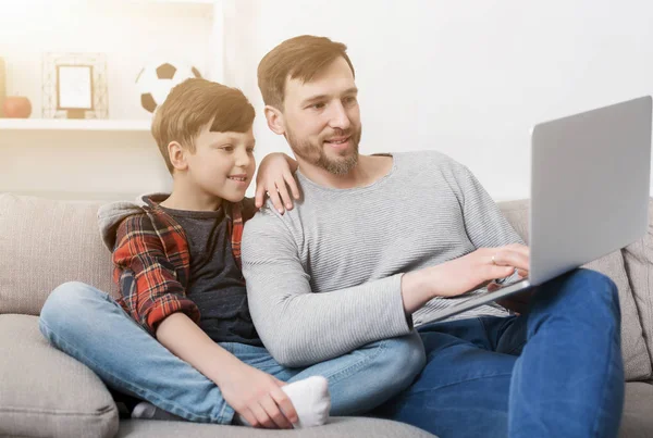 Far och son använder laptop hemma — Stockfoto