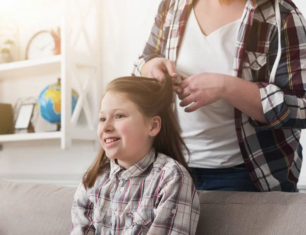 Mutter macht Zöpfe auf dem Haar ihrer Tochter — Stockfoto