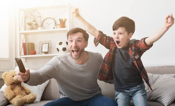 Pai e filho assistindo futebol na TV em casa . — Fotografia de Stock