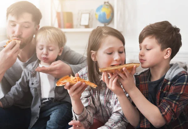 Porträt einer glücklichen Familie, die zu Hause Pizza isst — Stockfoto