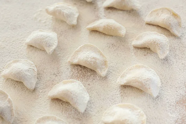 Masada pişmemiş el yapımı vareniki un serpilir