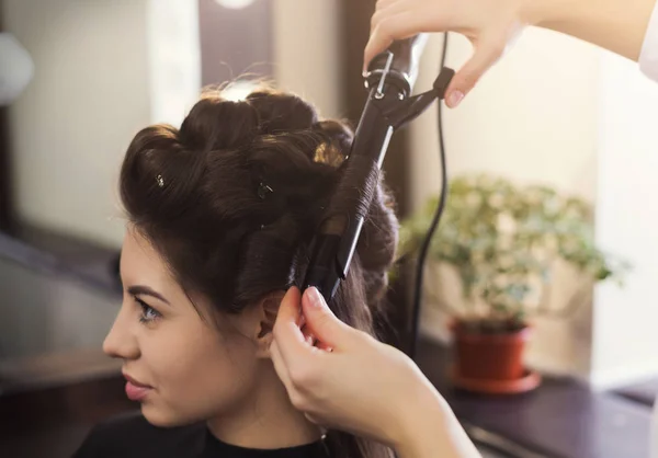 Frisör göra lockar på brun klienter hår — Stockfoto