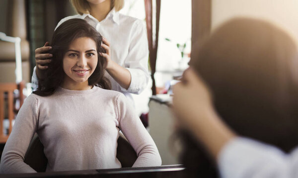Young beautiful woman discussing hairstyle with her hairdresser