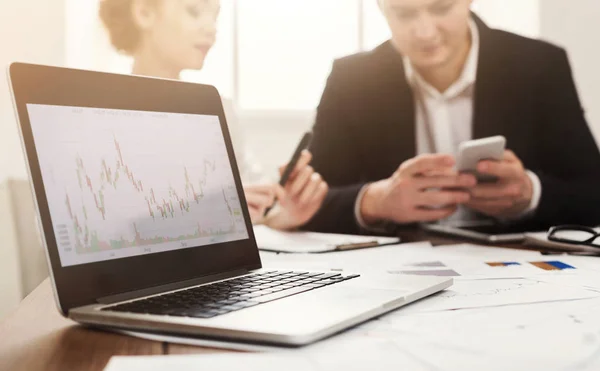 Laptop met financiële grafiek en zakelijke bijeenkomst — Stockfoto