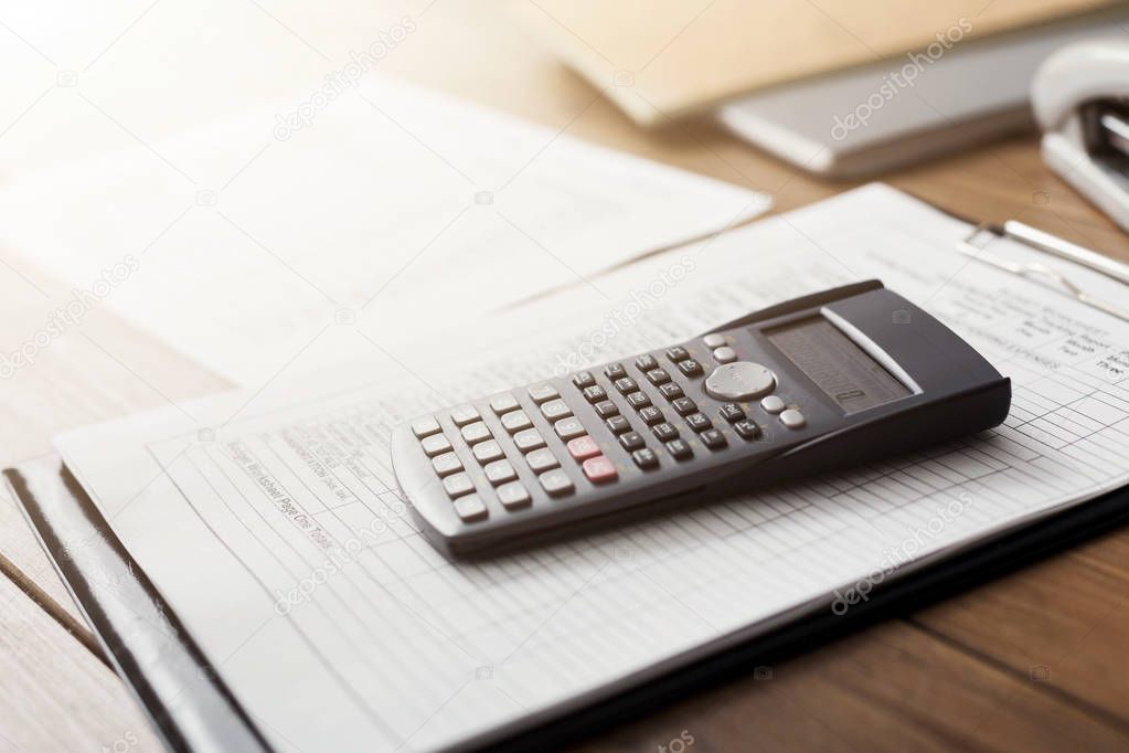 Calculator and documents on table in office