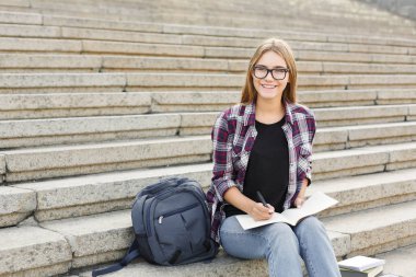 Genç öğrenci kız notları not defterinde yapma