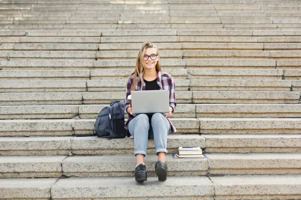 Estudiante feliz sentado en las escaleras usando portátil — Foto de Stock