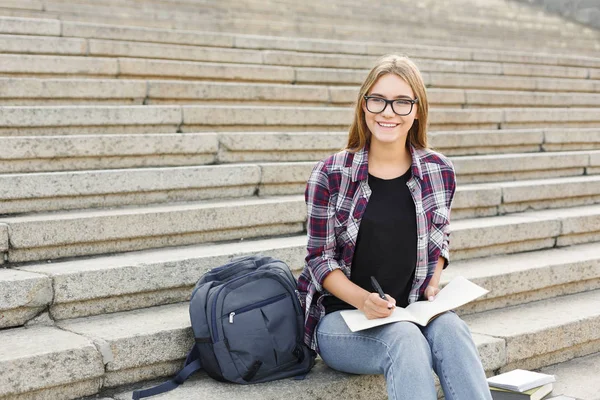 Genç öğrenci kız notları not defterinde yapma