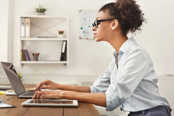 Ernstige zakenvrouw bezig met laptop op kantoor — Stockfoto