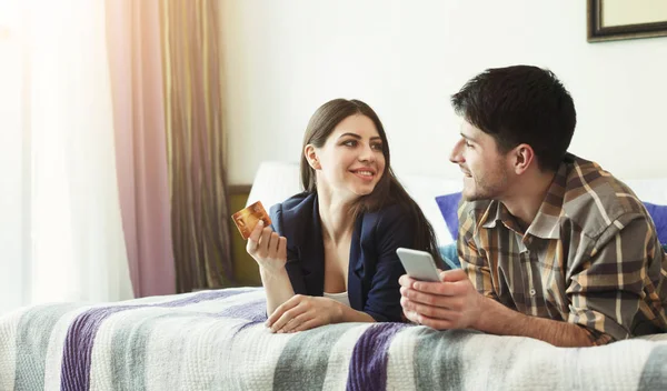 Casal feliz compras online com cartão de crédito e smartphone — Fotografia de Stock