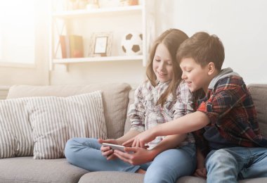 İki çocuk evde kanepe üstünde smartphone oynamak