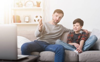 Mutlu baba ve oğul evde bir dizüstü bilgisayar bir film izlerken