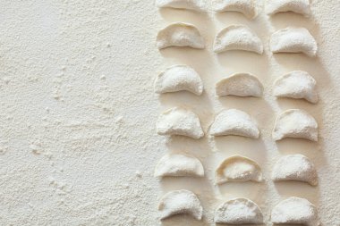 Tablo üzerinde ham el yapımı vareniki un serpilir