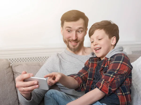 Divertido padre y su hijo tomando selfie en casa — Foto de Stock