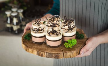 Tatlı tiramisu ile ahşap tepsi gözlük tutan Şef