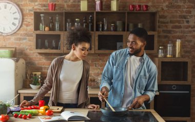 Sevgi dolu siyah çift akşam yemeği birlikte mutfak hazırlanıyor