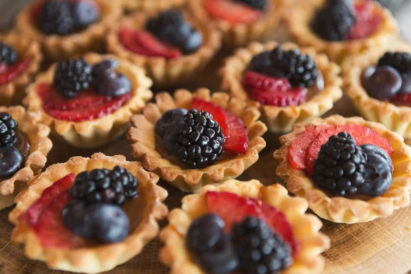 Berry tartlets dessert on wooden background — Stock Photo, Image