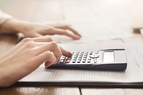 Mujer usando calculadora con control de finanzas en casa — Foto de Stock