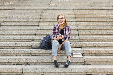 Açık havada Smartphone kullanan mutlu genç kadın