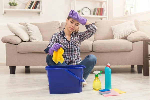 Jonge vrouw moe van voorjaarsschoonmaak in huis — Stockfoto