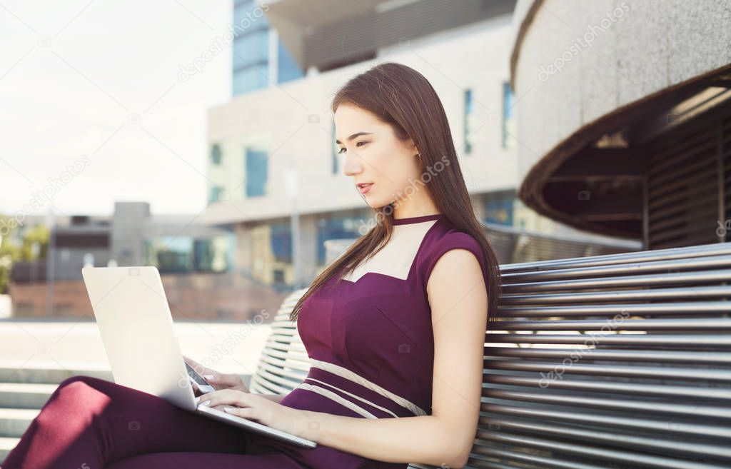 Caucasian businesswoman working with laptop outdoors
