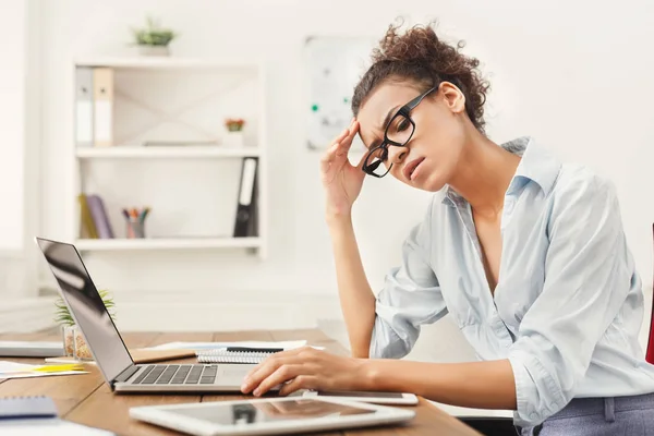 Frustrierte Geschäftsfrau mit Kopfschmerzen im Büro — Stockfoto