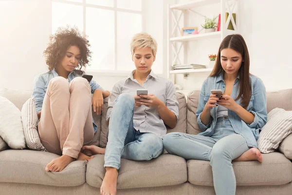 Tres amigas usando smartphones en casa — Foto de Stock