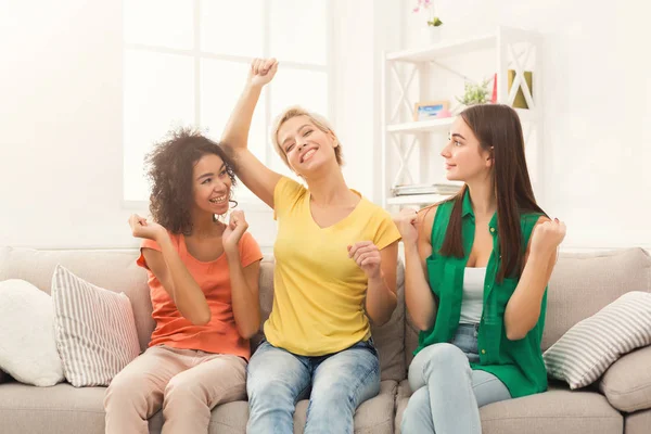 Mutlu arkadaşlar evde eğlenmek renkli giysiler içinde. Gülüyor ve dans, pijama partisi, üç genç kadın alanı Kopyala