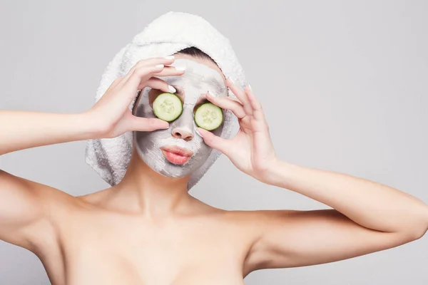 Beautiful girl with applied clay mask at grey background — Stock Photo, Image