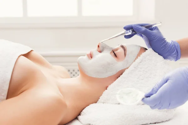 Mulher recebe máscara facial por esteticista no spa — Fotografia de Stock